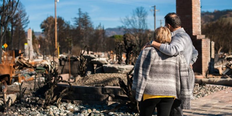 Couple Standing By Burnout Home— Bushfire Services In Newcastle, NSW
