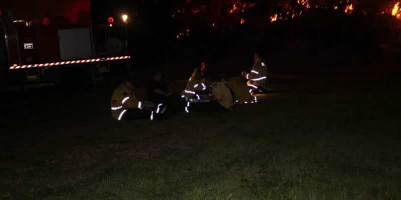 Group Of Firefighter Sitting On The Grass — Bushfire Services In Newcastle, NSW